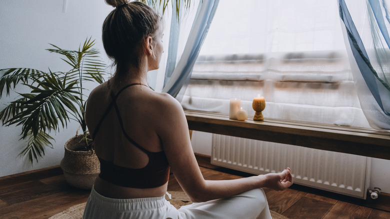 Woman meditating in front of a window