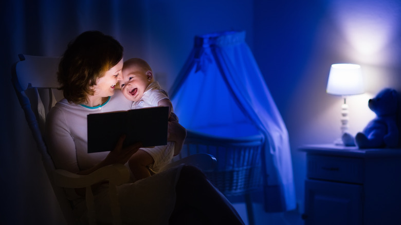 adult and baby reading a e-book in dark bedroom