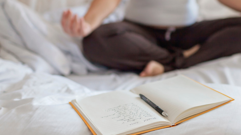 woman journaling on bed