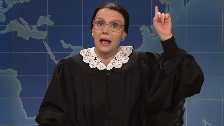 Kate McKinnon as RBG behind the "Weekend Update" desk, pointing up