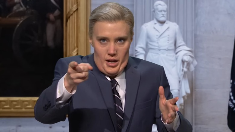 Kate McKinnon with big jowls as Lindsey Graham, pointing at the camera