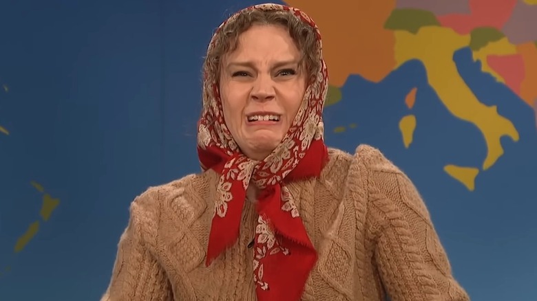 Kate McKinnon looking scared in a red headscarf as an old Russian lady on "SNL"