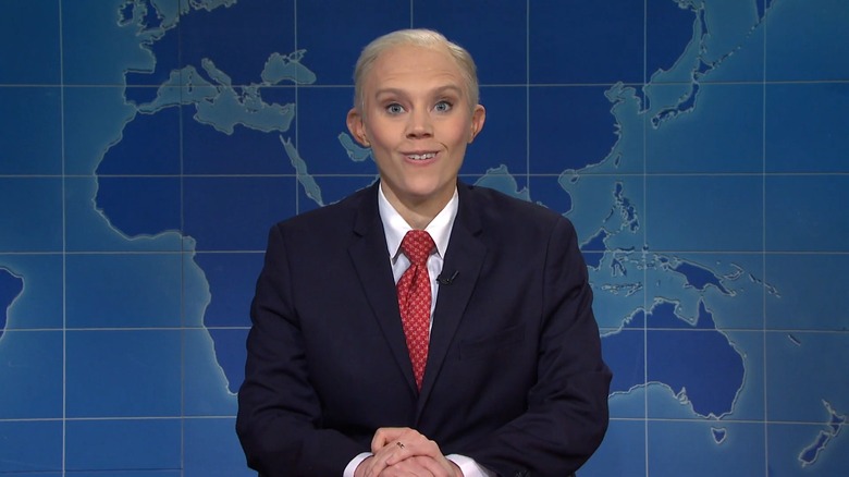 Kate McKinnon dressed as Jeff Sessions with a goofy smile, sitting at the "Weekend Update" desk