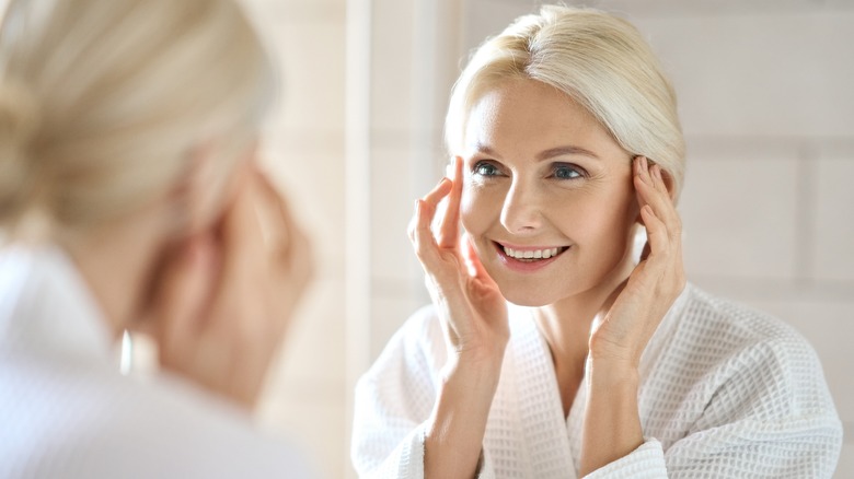 Woman looking into mirror smiling