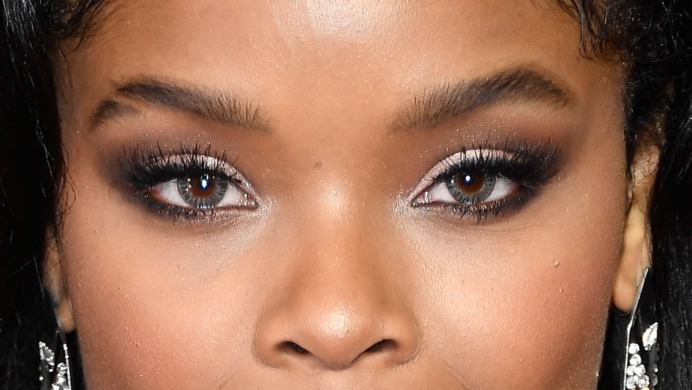 A woman's face with eyebrow slits, close-up