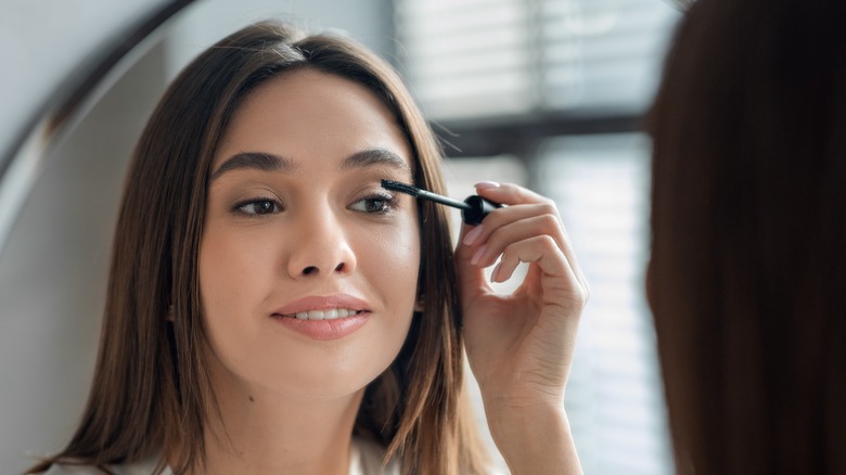 Woman applying mascara