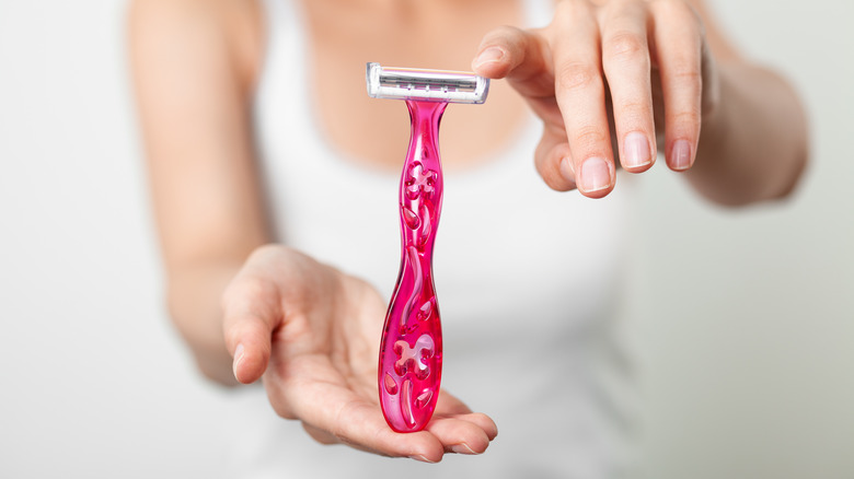 Woman holding pink razor