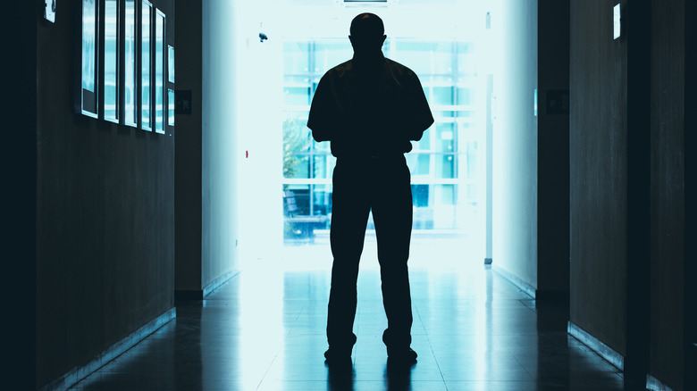 man standing in florescent lighting inside modern looking building