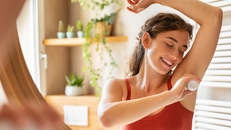 Woman applying deodorant