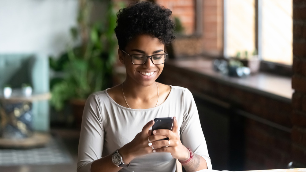 Woman smiling while texting