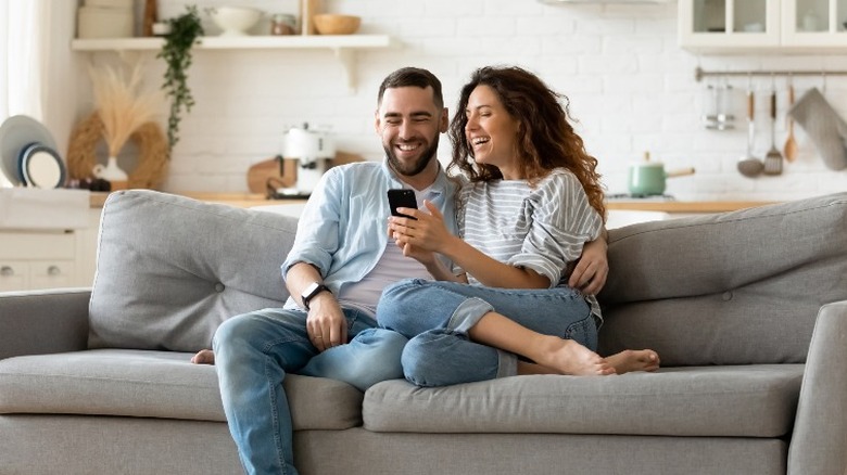 man woman cellphone couch