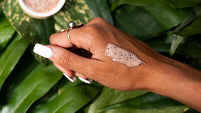 grainy pink skin scrub on woman's hand