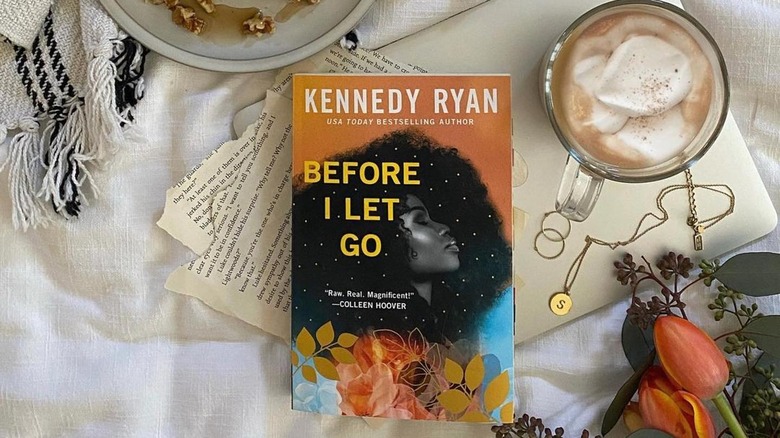 "Before I Let Go" by Kennedy Ryan next to cup of coffee and flowers