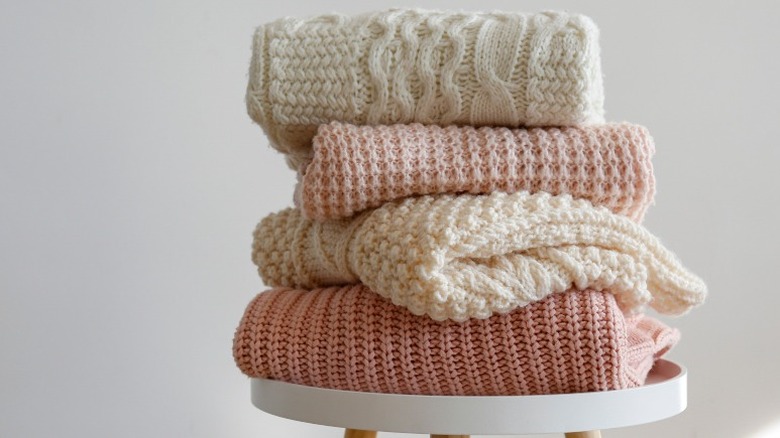 stack of cream and pink cable knit sweaters