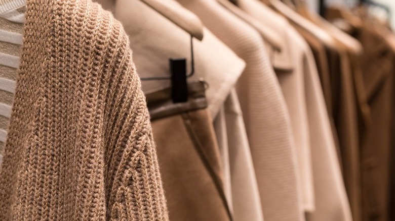 hanging beige sweaters and jackets