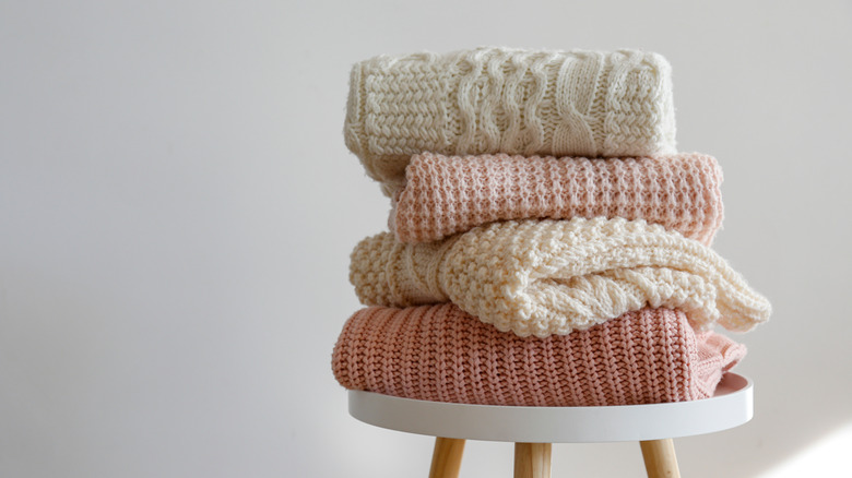 Pile of jumpers on chair