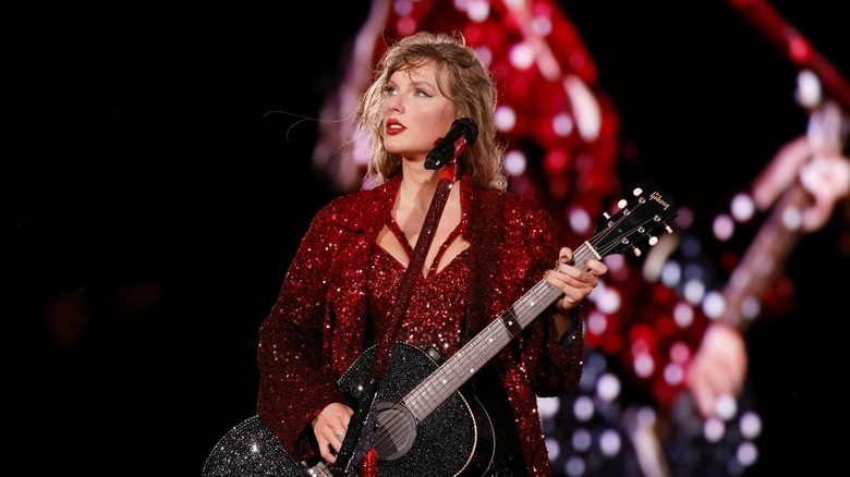 Taylor Swift playing guitar during the 'Red' section of the Eras Tour