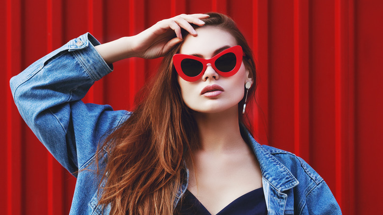 Woman with red cat-eye sunglasses and a jean jacket