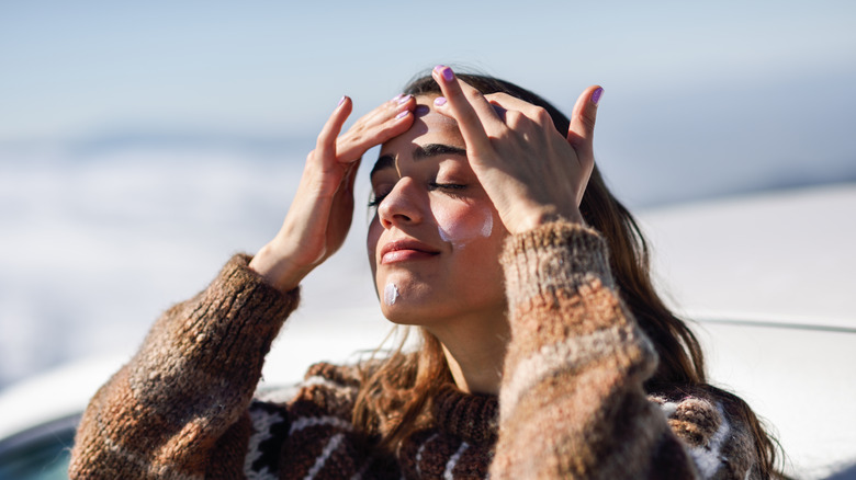 Woman applying sunscreen to the face 