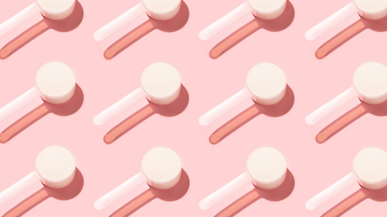 Scoops of protein sitting on a pink background