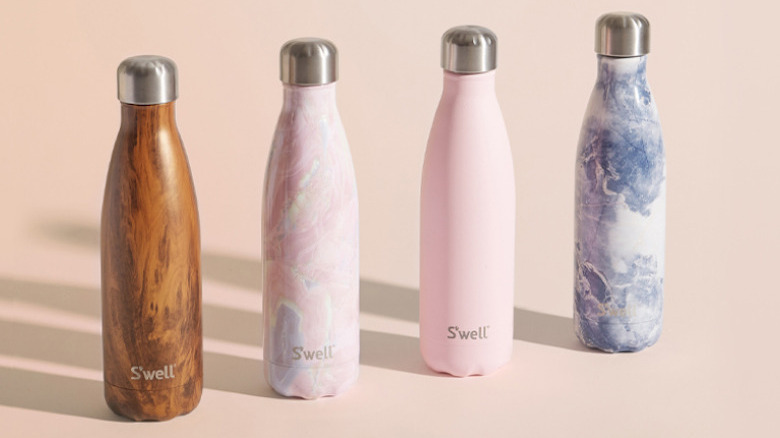 Two stainless steel water bottles against a taupe background