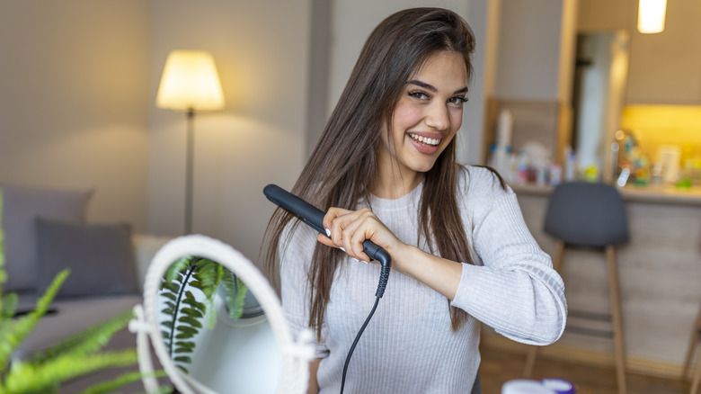 woman flat ironing hair