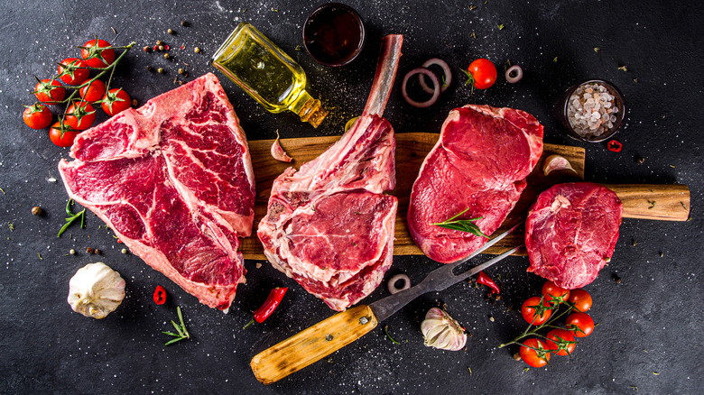 Raw steak on a board with vegetables