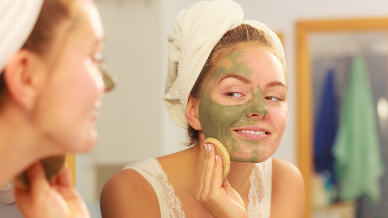 woman removing green clay mask