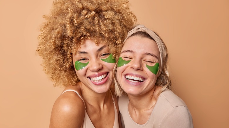 Two women with green under eye patches
