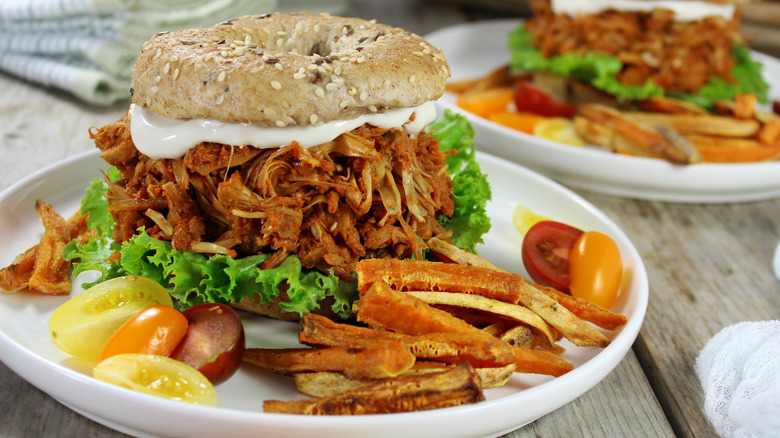 Jackfruit sandwich with fries and tomatoes