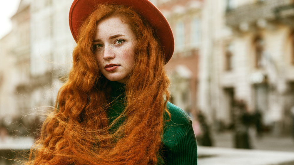 A red-haired woman looking at the camera