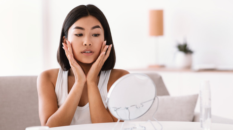 Woman touching glowy face