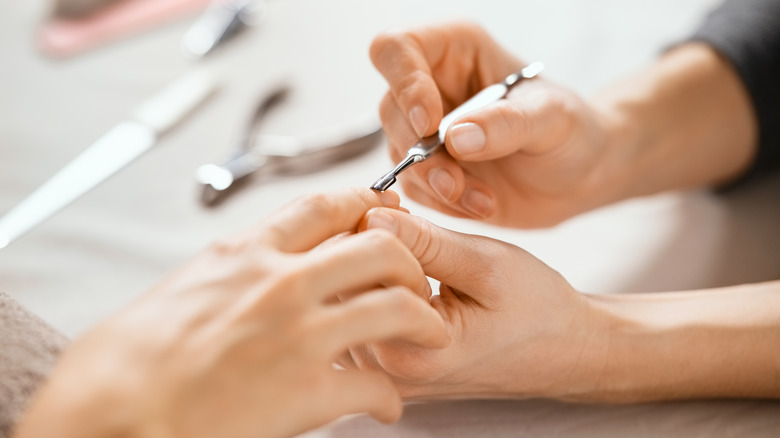 Using a cuticle pusher on nails