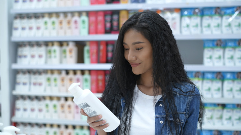 Woman choosing hair product from shelf