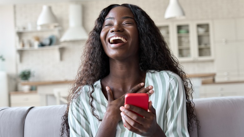 Woman holding phone and laughing