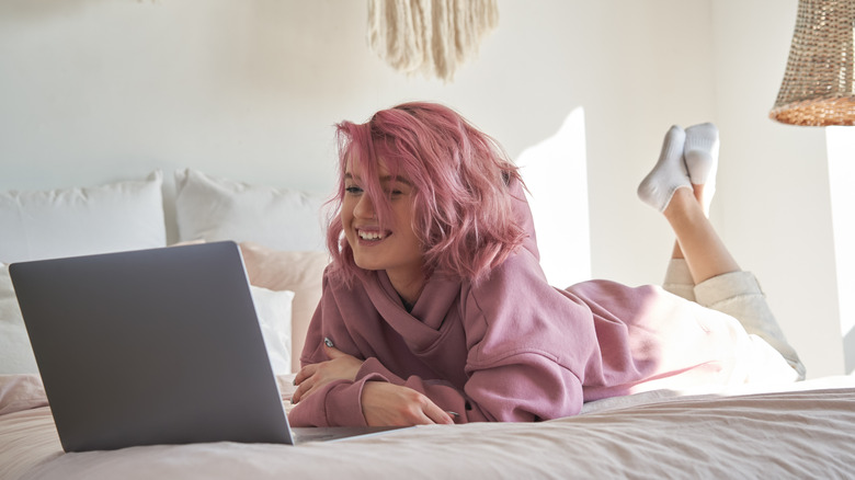 Woman laying in bed with a laptop