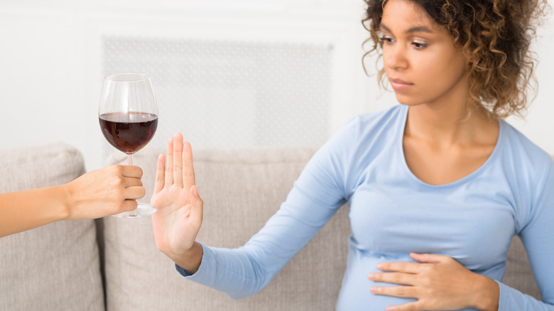 pregnant woman rejecting wine