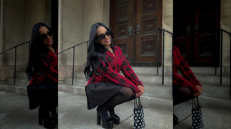 @juju.stylez squatting in red and black outfit