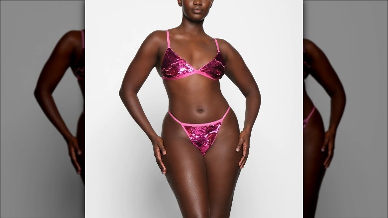 Skims model wears pink sequined lingerie set 