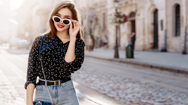 Woman in belted jeans and sunglasses