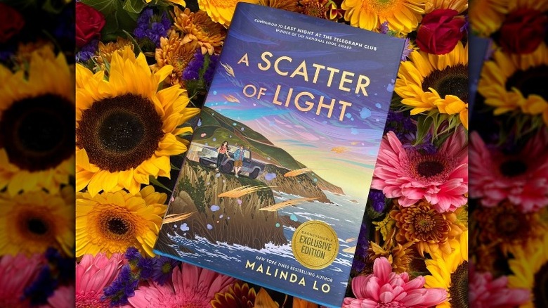 "A Scatter of Light" by Malinda Lo on a bed of flowers