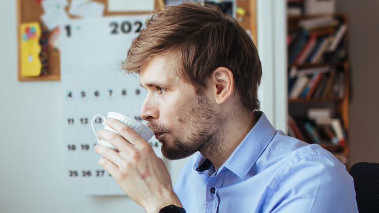 A man drinking coffee in an office