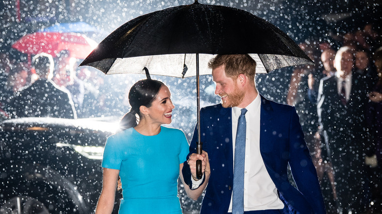 Meghan and Harry under umbrella