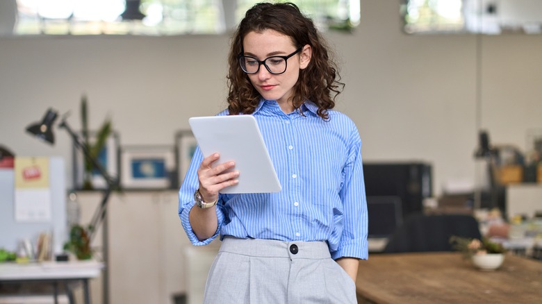 Woman looks at her tablet at work