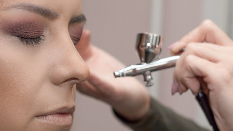 Artist applying airbrush makeup