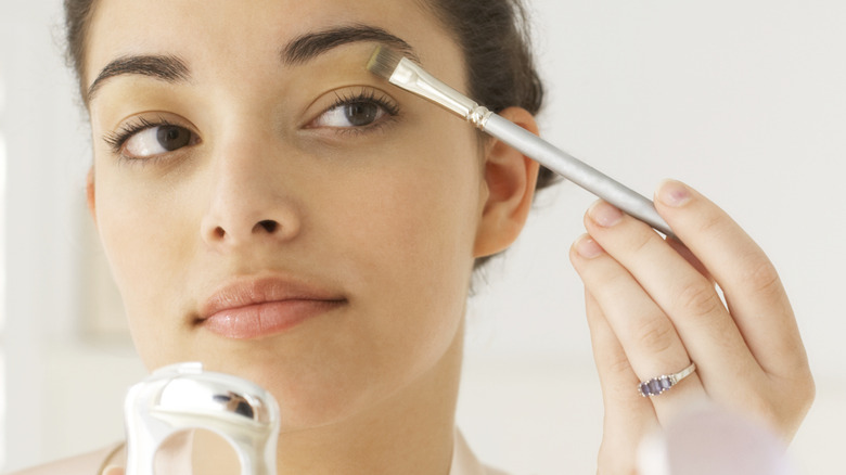 Woman touching up makeup