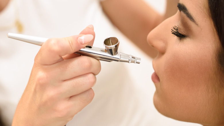 Woman receiving airbrush makeup