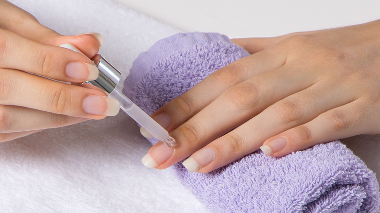 woman applying cuticle oil