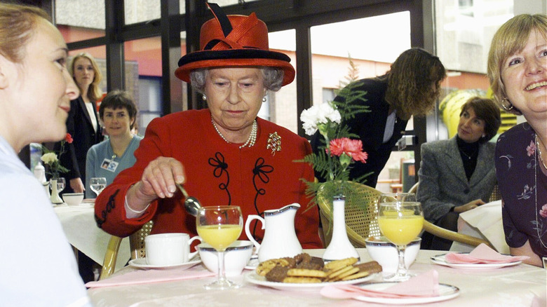 Queen Elizabeth II eating with guests