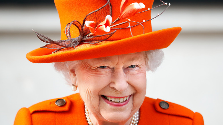 Queen Elizabeth II smiling in orange